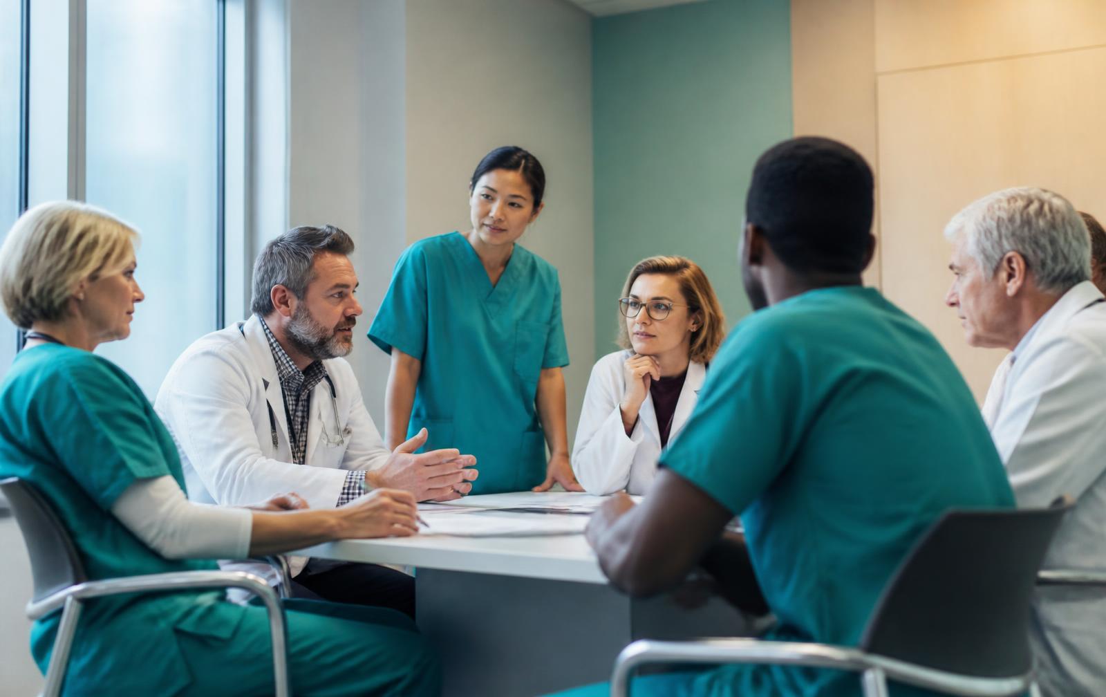 Equipo clínico interdisciplinar reunido en un hospital para revisar un proceso asistencial